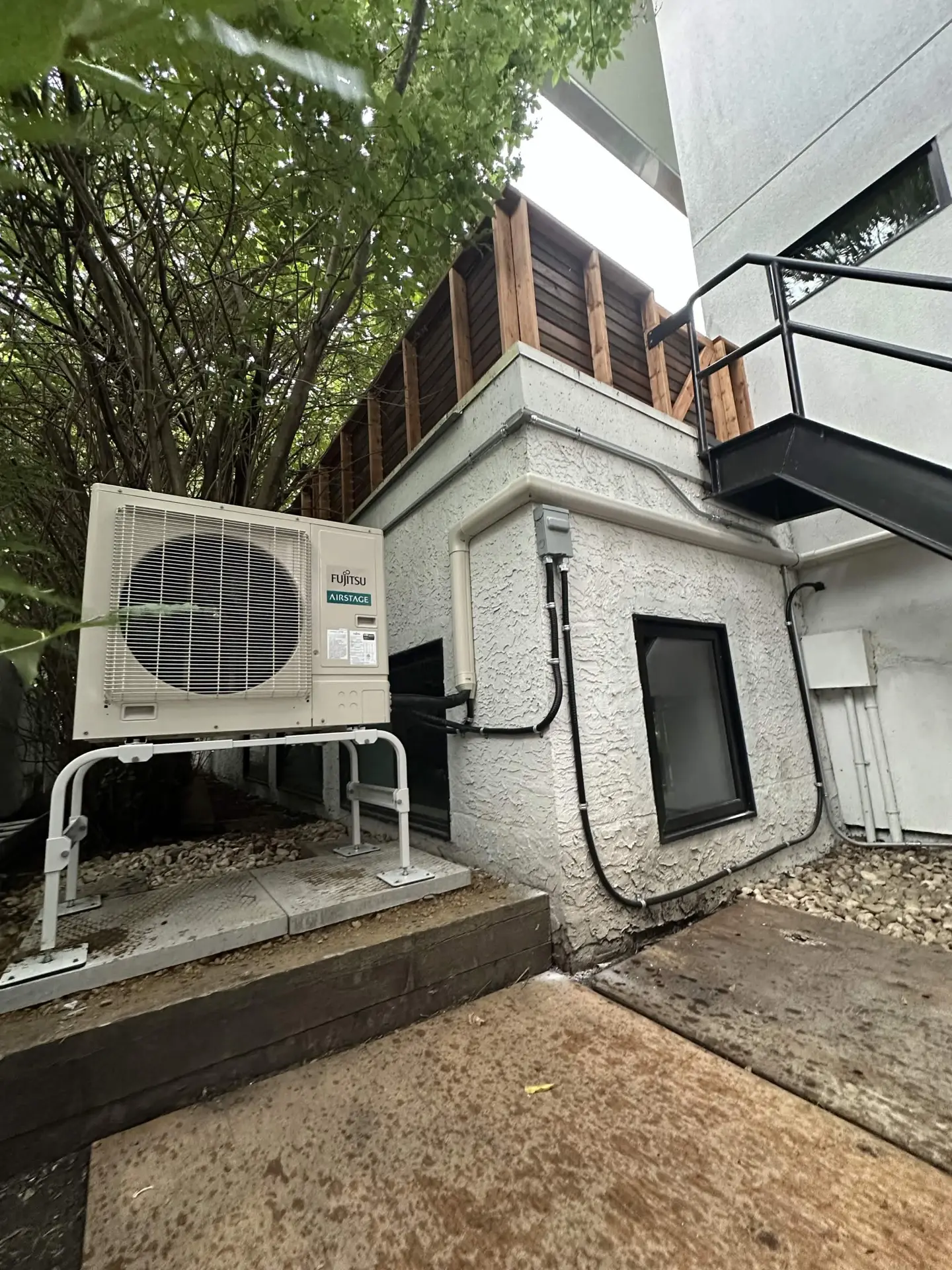 Fujitsu Airstage outdoor condenser on a ground-level pad