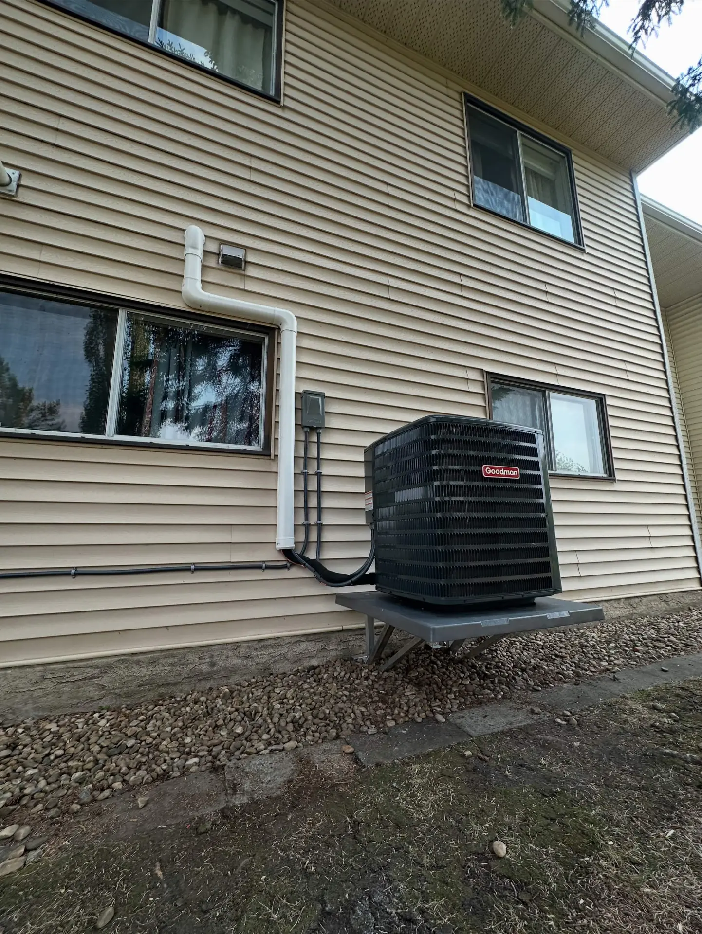 Goodman air conditioner on an elevated wall-mounted platform
