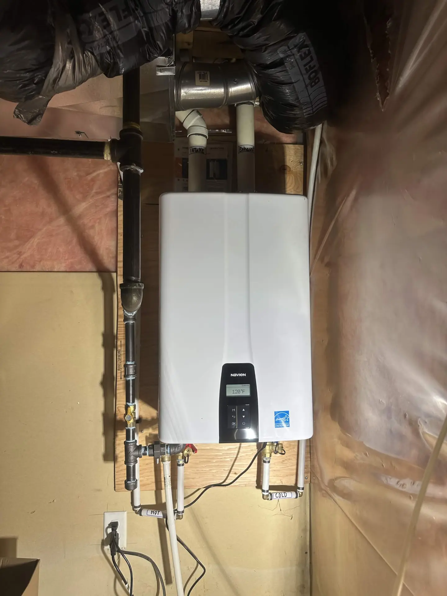 Wall-mounted Navien tankless water heater with finished gas and water lines