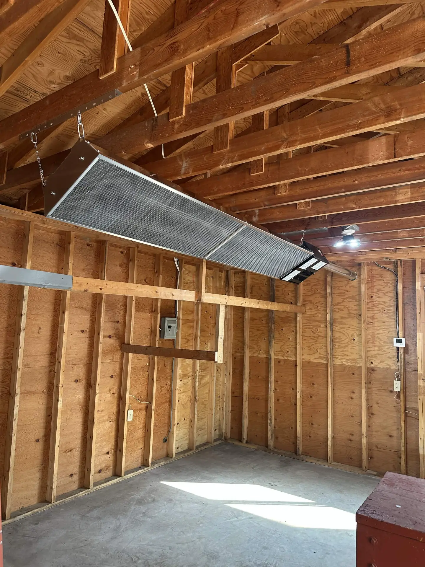 Overhead infrared radiant heater in a wood-framed shop