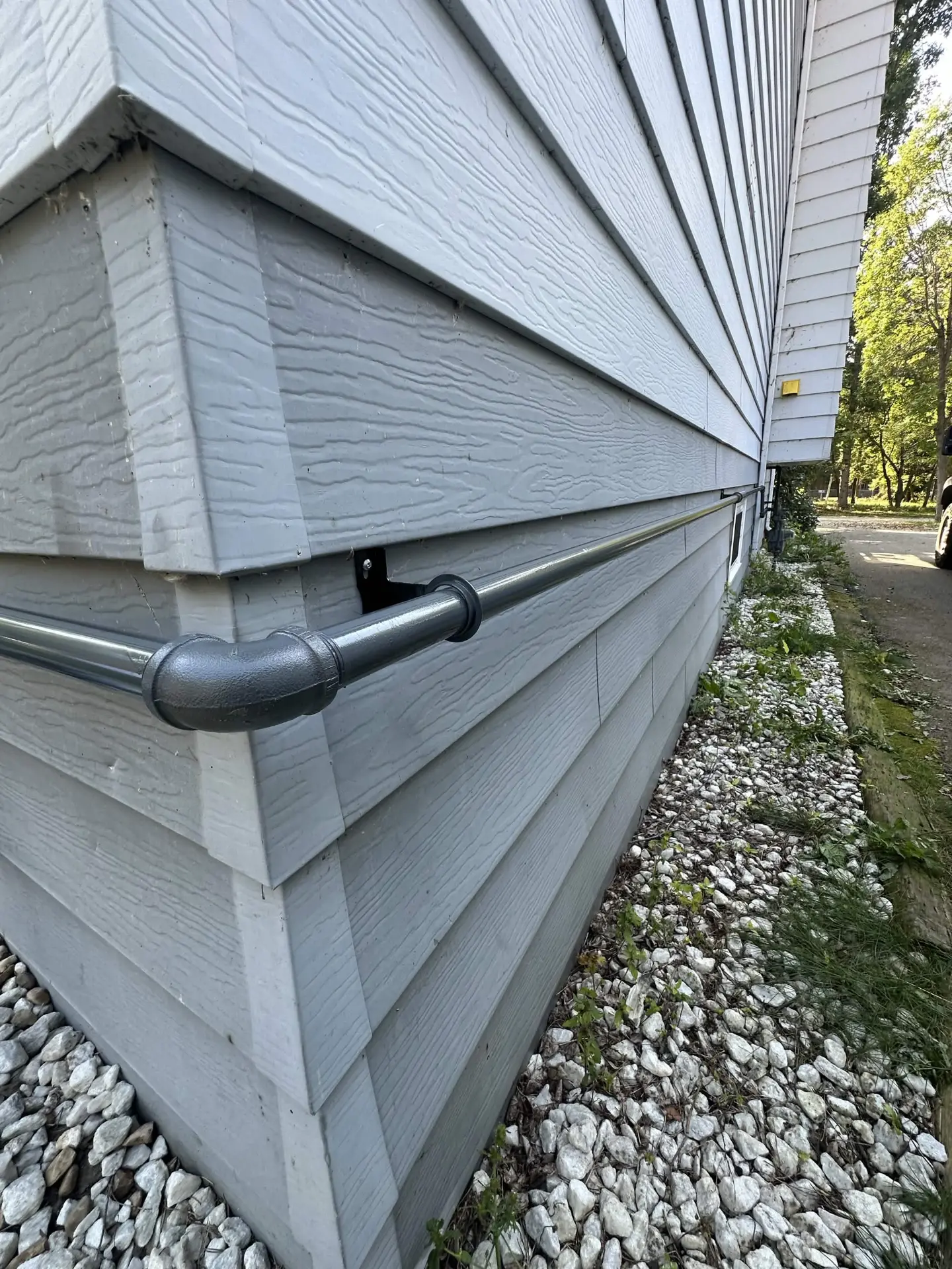Black iron gas piping run along the exterior of a home