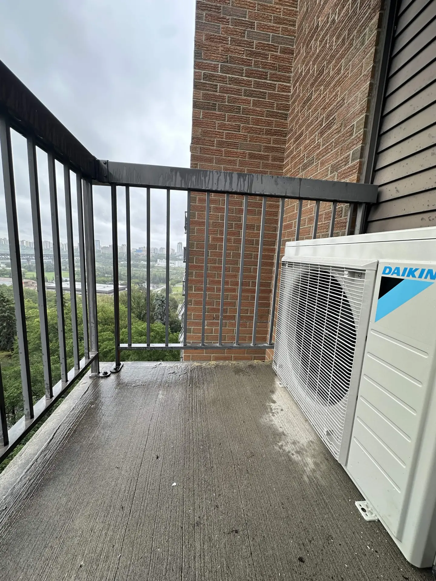 Daikin outdoor heat pump unit installed on a high-rise balcony
